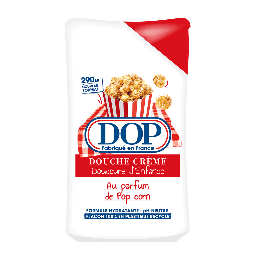 Front view of a white bottle of DOP Douche Crème Douceurs d’Enfance au parfum Pop Corn, featuring an image of caramel popcorn in a red-and-white striped box. The label highlights a 290 ml format, hydrating formula, pH neutral, and a bottle made from 100% recycled plastic.