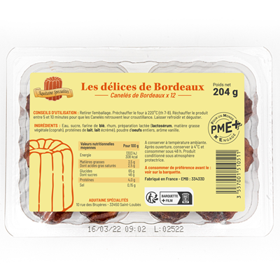 Back view of a plastic tray containing Les Délices de Bordeaux Canelé Bites (12 x 17g), showing product details, usage instructions, and a yellow label with nutrition facts and storage guidance in French. The label highlights the artisanal nature of the product, with PME+ and French origin certification.


