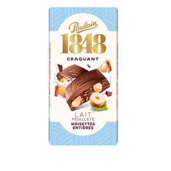 A package of Poulain 1848 Craquant Lait Feuillete Noisettes Entières chocolate bar, featuring a white and light blue wrapper with gold and brown illustrations of chocolate and hazelnuts.