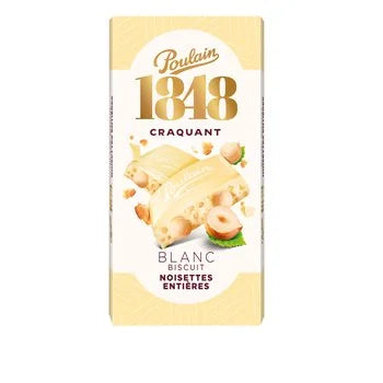 A package of Poulain 1848 Craquant Blanc Biscuit Noisettes Entieres, featuring a pale yellow and white wrapper with illustrations of a biscuit, hazelnuts, and green mint leaves.