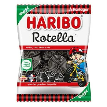 Packaging of Haribo Rotella Liquorice Sweets 300g, featuring black coiled liquorice wheels, a cartoon child riding a bicycle, and labels indicating “Sans colorant artificiel” (no artificial colouring) and “Veggie.” The design includes a red and black striped border and the Haribo slogan “pour les grands et les petits.”