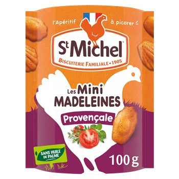 Packaging of St Michel Mini Madeleines Provençale 100g featuring an orange and purple design with images of mini madeleines, a tomato, and herbs. The label highlights “sans huile de palme” (no palm oil) and includes the St Michel logo with a white chicken silhouette.

